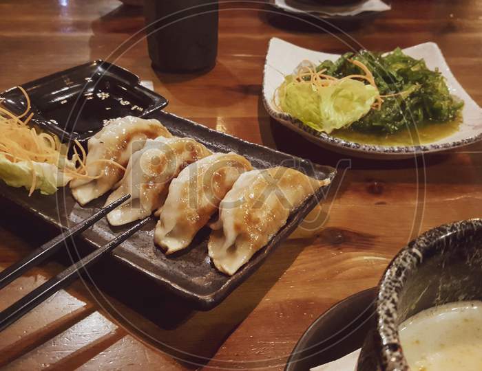 Gyoza Lightly Fried. Soy Sauce And Vegetables.