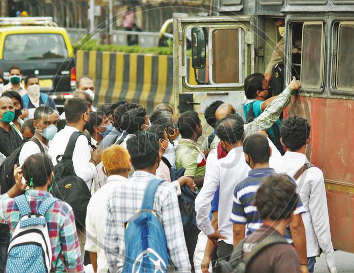 People scramble to enter a public bus, after the government eased a nationwide lockdown that was imposed as a preventive measure against the COVID-19 coronavirus, in Mumbai, India, on June 26, 2020.