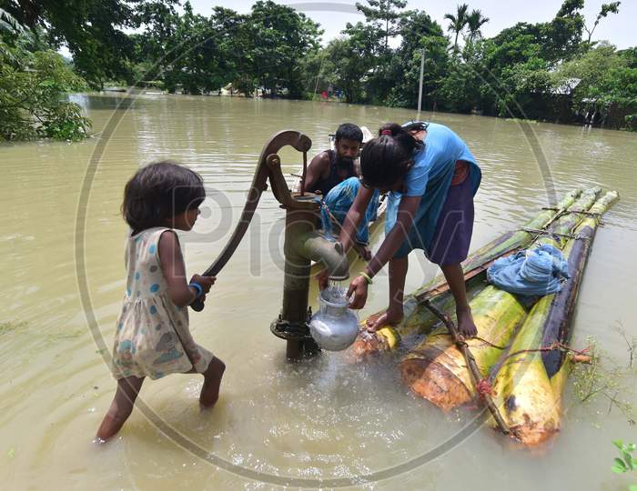 Girls Collect Drinking Water From A Partially submerged  Hand Pump At  Mayong Village In Morigaon District Of Assam On June 29, 2020