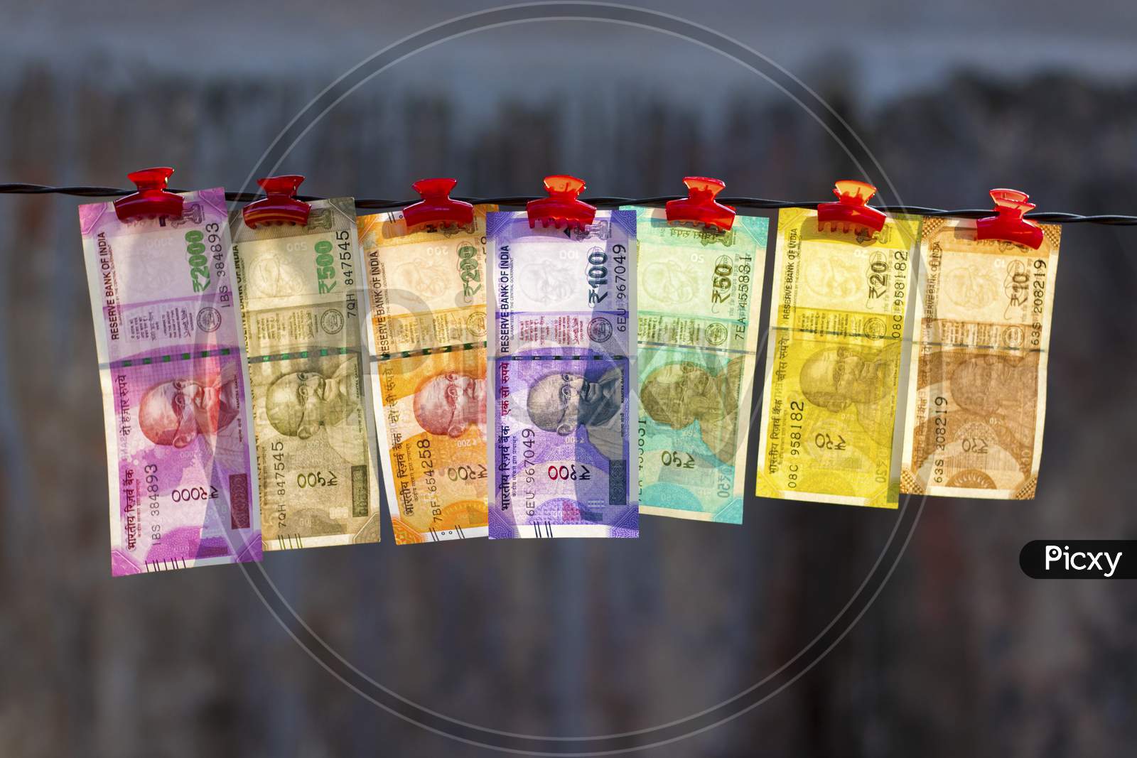 selective focus of new Indian currency notes rupees ten,twenty,fifty hundred,two hundred,five hundred and two thousand hanging in a wire.