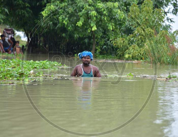 A man Wades Through The Flood Water At  Sildubi Village In Morigaon District Of Assam On June 29,2020.