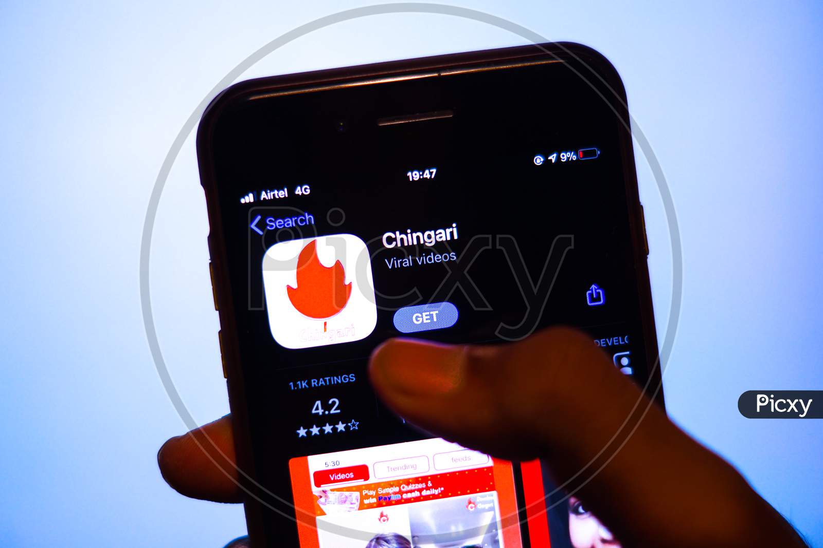 Chingari App on Mobile screen with a finger about to Download the App from the AppStore