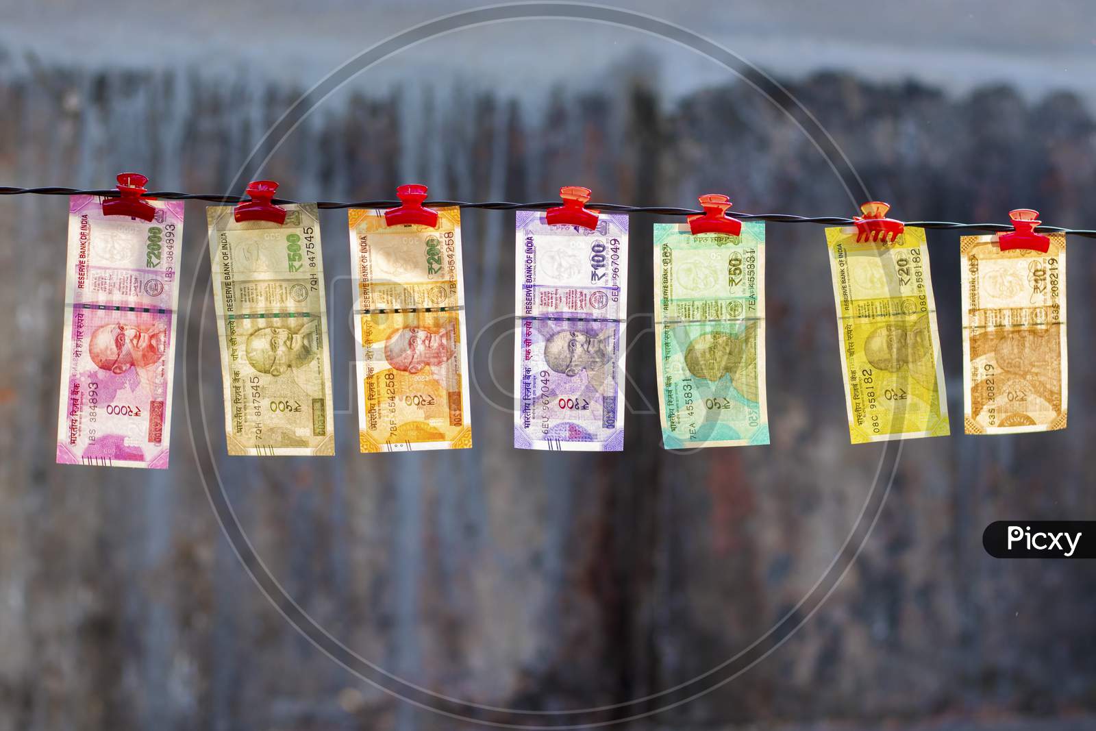 selective focus of new Indian currency notes rupees ten,twenty,fifty hundred,two hundred,five hundred and two thousand hanging in a wire.