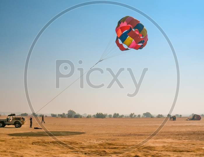 Jeep Towing A Parachute For Adventure Para Gliding In The Empty Barren Thar Desert In Rajasthan Near Jaisalmer And Sum