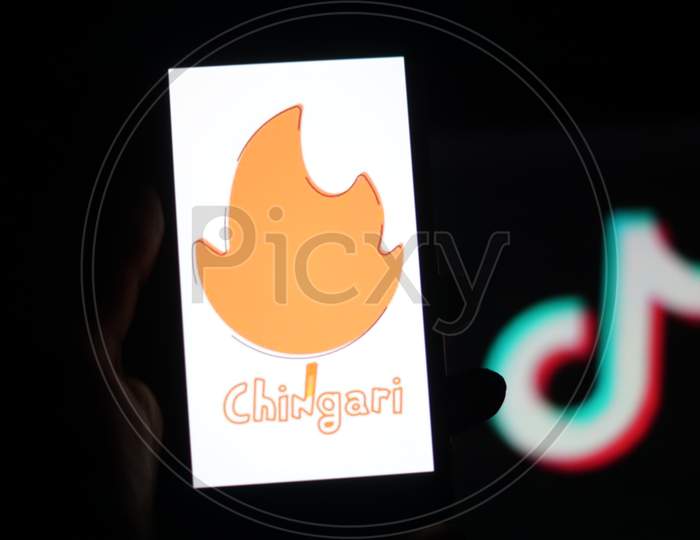 Chingari App logo on Mobile screen with Banned Tiktok Application Logo in the background