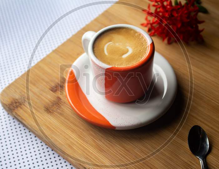 Freshly Brewed Sparkling Coffee In A Small Orange And White Mug. Cup With Typical Brazilian Drink On A Wooden Board. Copy Space.
