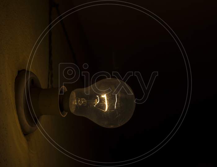 A Old Bulb With Filament And Dark Background