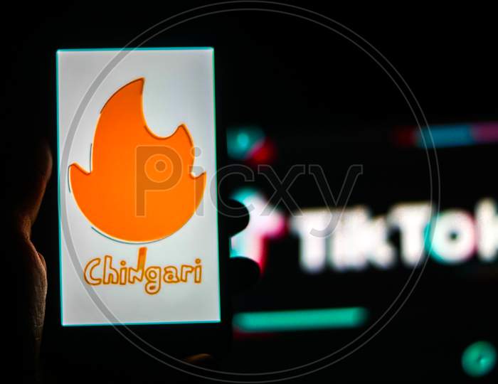 Chingari App logo on a Mobile screen with Banned Tiktok Application Logo in the background
