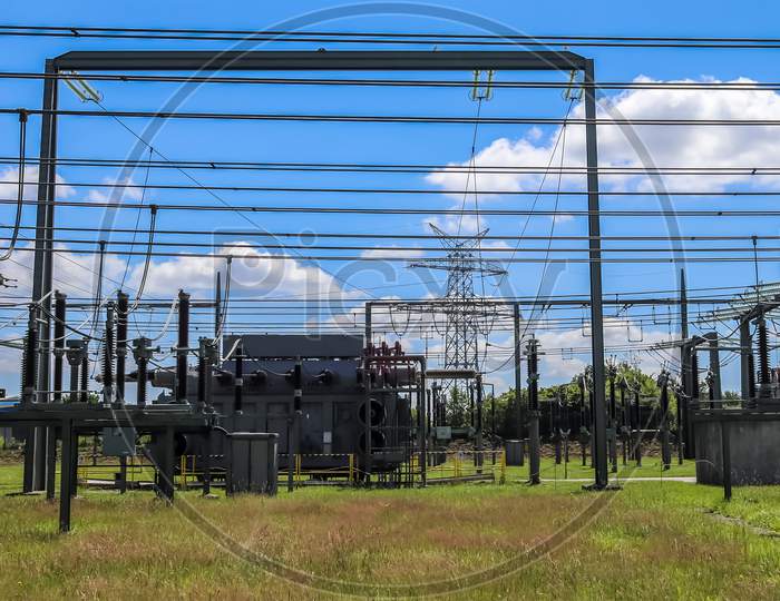 Electrical Transformer. Distribution Of Electric Energy At A Big Substation With Lots Power Lines On A Sunny Day