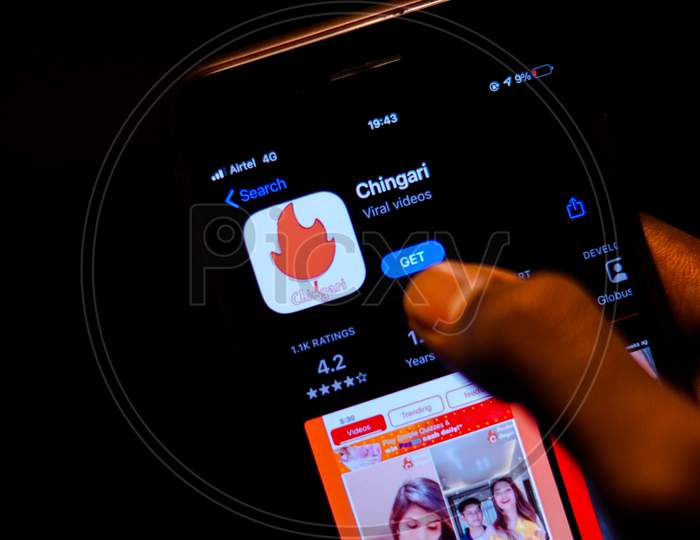 Chingari App on Mobile screen with a finger about to Download the App from the AppStore