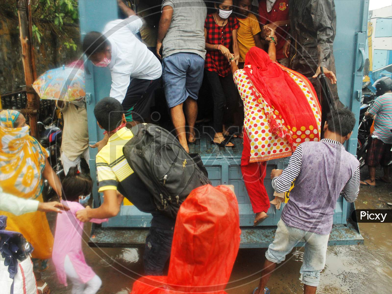 People scramble to enter a truck during an evacuation of a slum off the coast of the Arabian sea in Mumbai, India as cyclone Nisarga makes its landfall, on the outskirts of the city, June, 3, 2020.