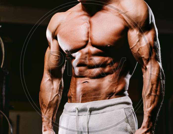 Muscular Fit Man Pumping Muscles.