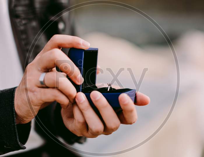 Man Holding Engagement Ring In Box For Proposal