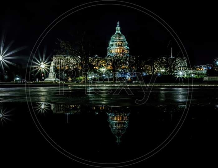 The capitol in Washington D.C., United States of America at a cold night in spring with reflections in water.