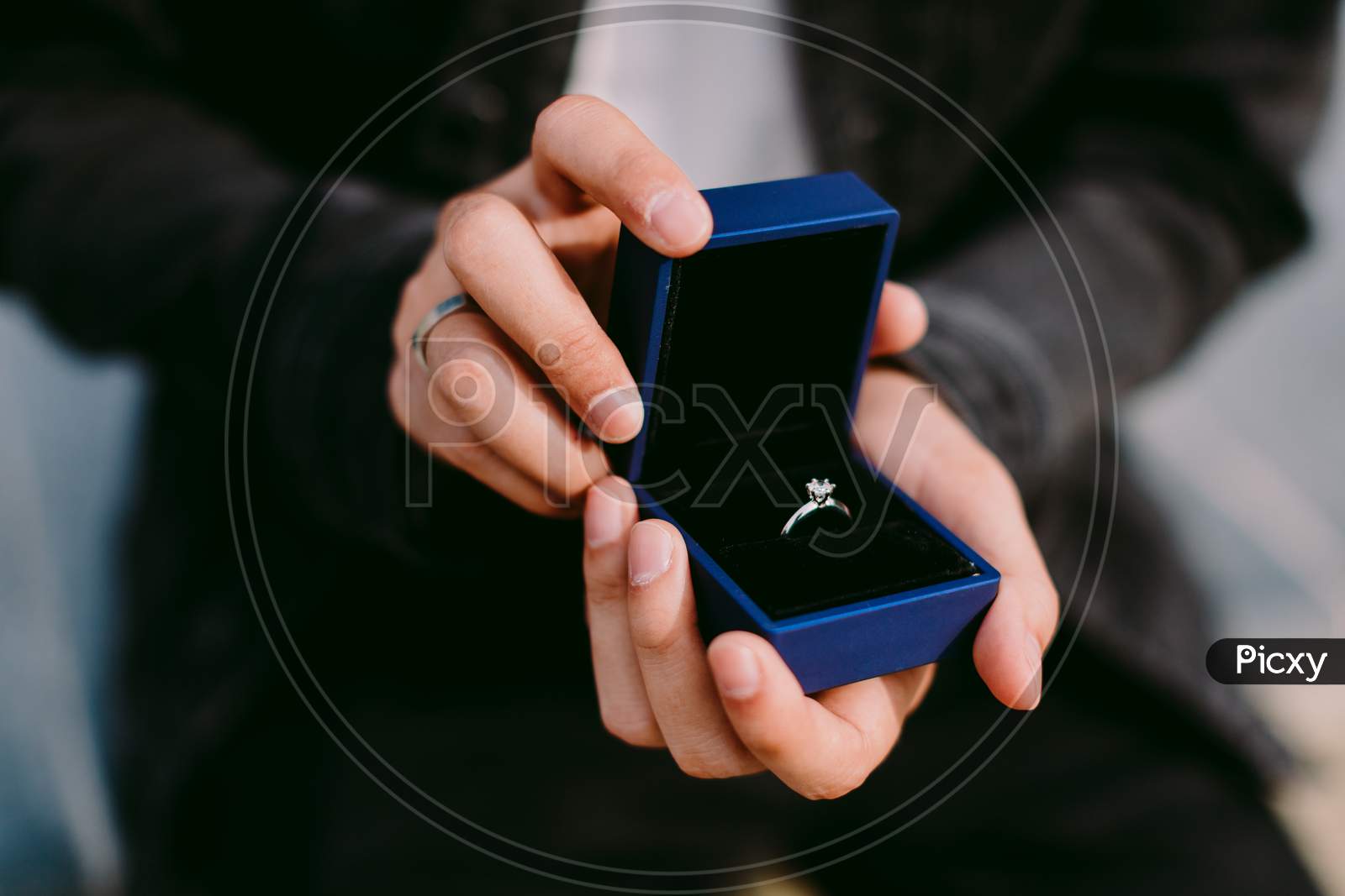 Man Holding Engagement Ring In Box For Proposal