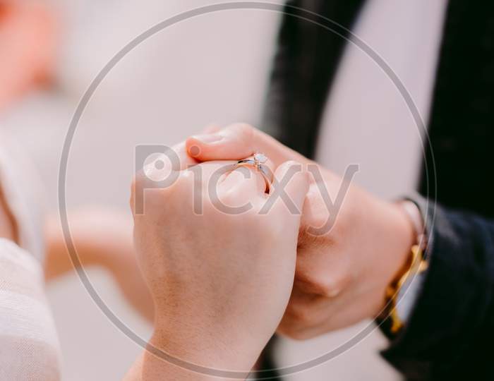 Engaged Couple Holding Hands With Engagement Ring