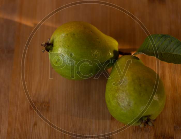 Two Guavas On A Wooden Table. Free Space To Write. Food For Vegetarians And Vegans.