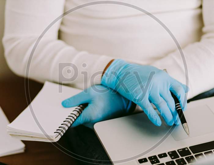 Man Using Laptop And Wearing Latex Gloves At Home Quarantine