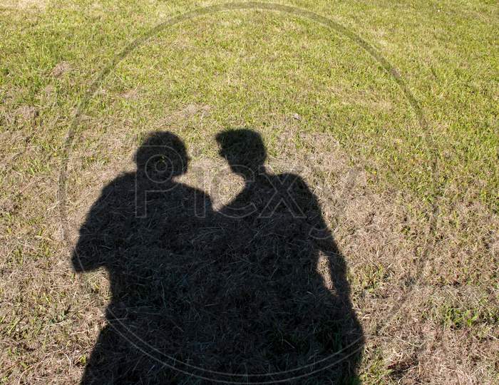 Shadow Of A Woman And Man In A Green Field. Shadow Of A Couple Together