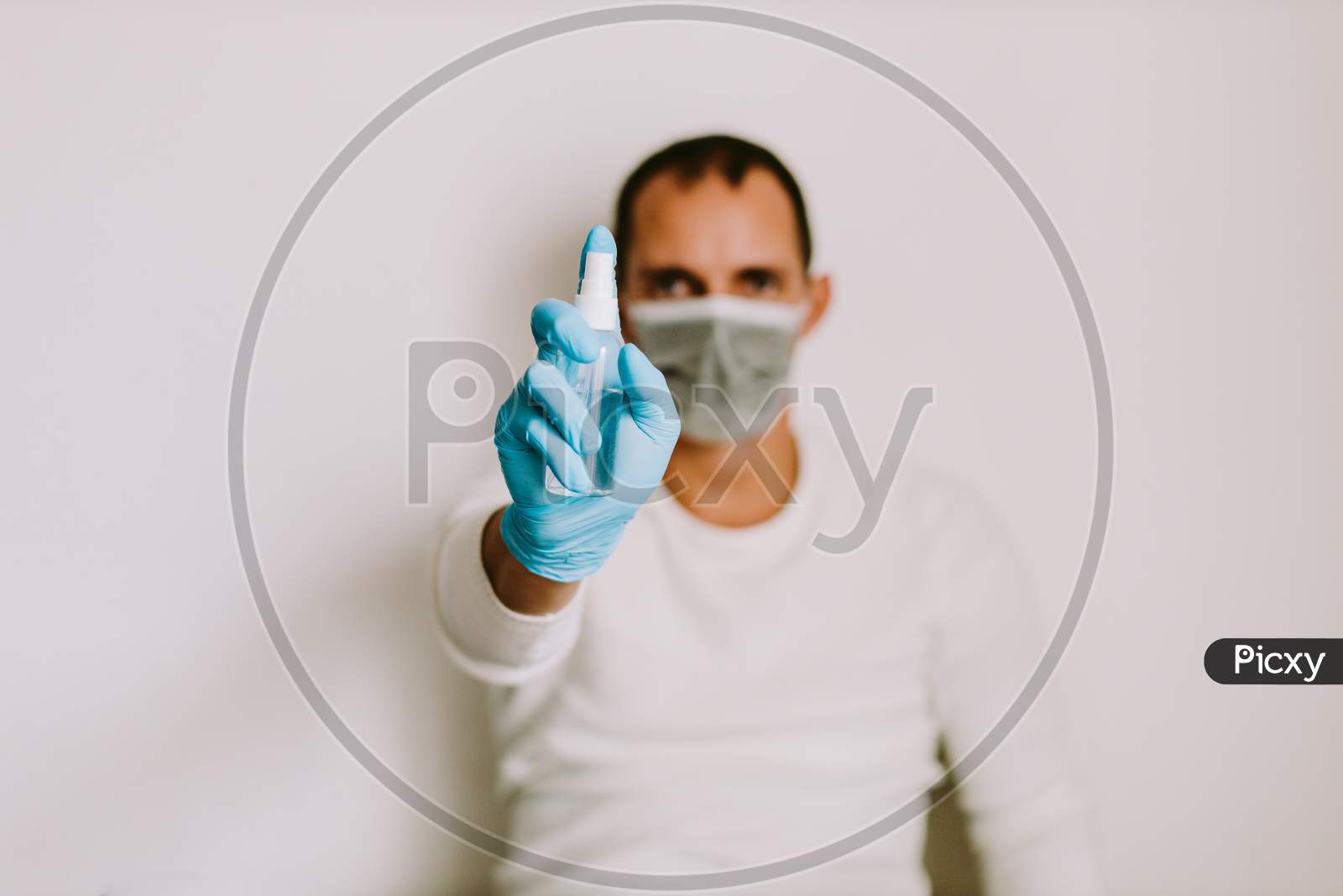 Man Using Liquid Hand Sanitizer During Quarantine At Home