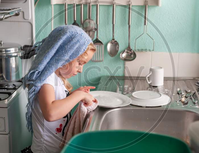 Pretty Young Girl Drying Dishes At The Sink