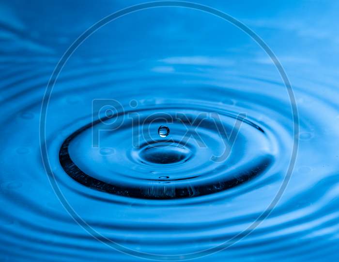 High Speed Water Drop Photography. Blue With Single Drop About To Splash