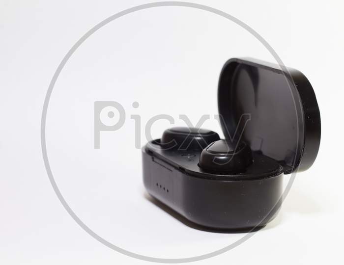 Black Wireless Earphones And The Case Isolated On White Background. True Wireless Stereo Earphones. Wireless Earphones With Its Case