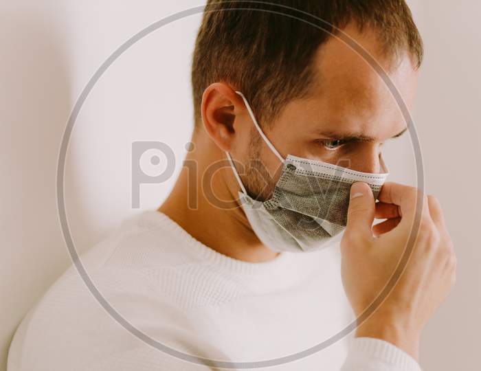 Man Using Face Mask For Virus Prevention At Home