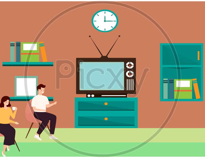 Couple Watching News At Home With A Cup Of Tea