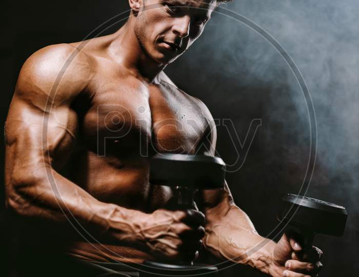 Brutal Strong Bodybuilder Man Pumping Up Muscles In Gym