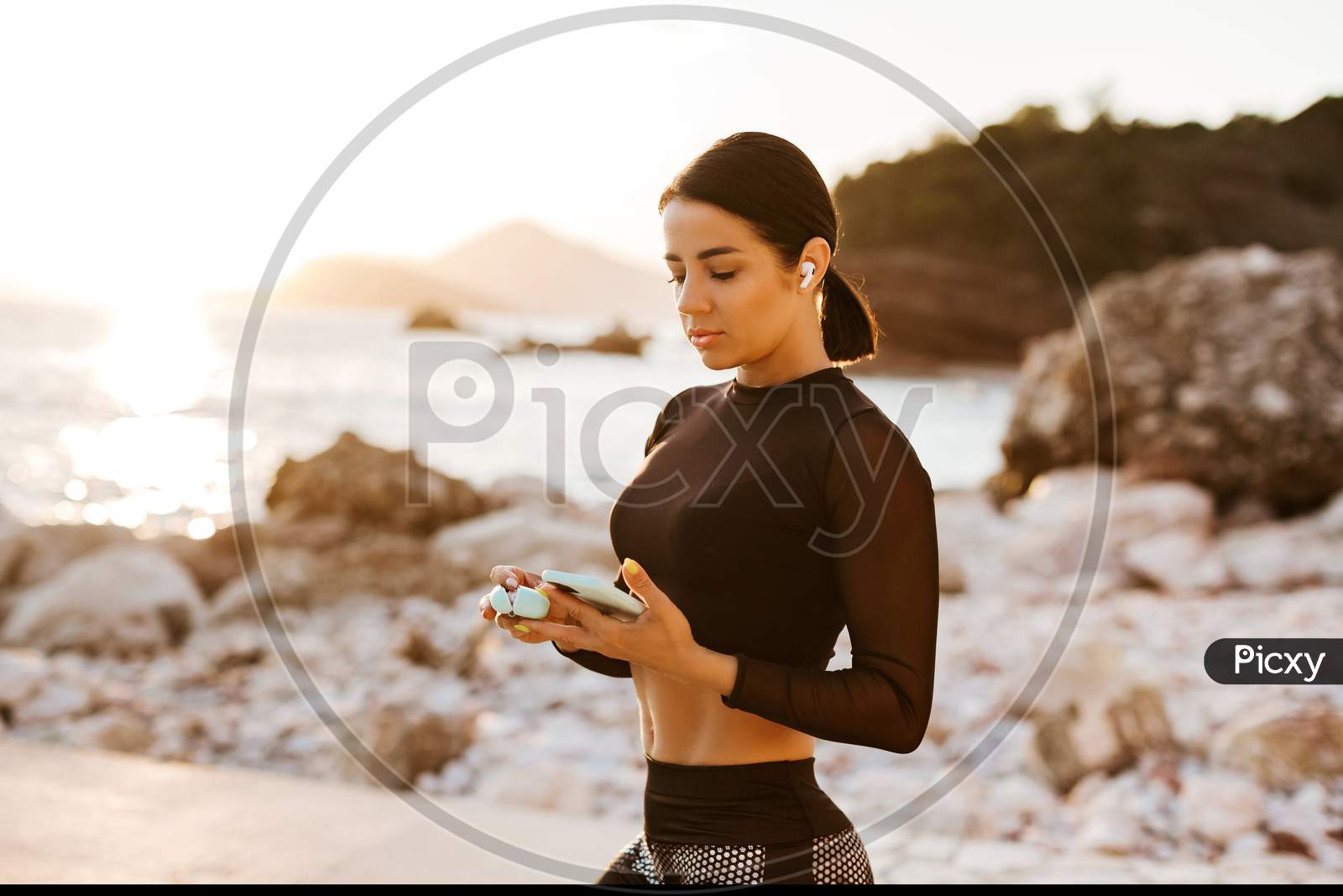 Sporty Girl Training With Phone And Earbuds