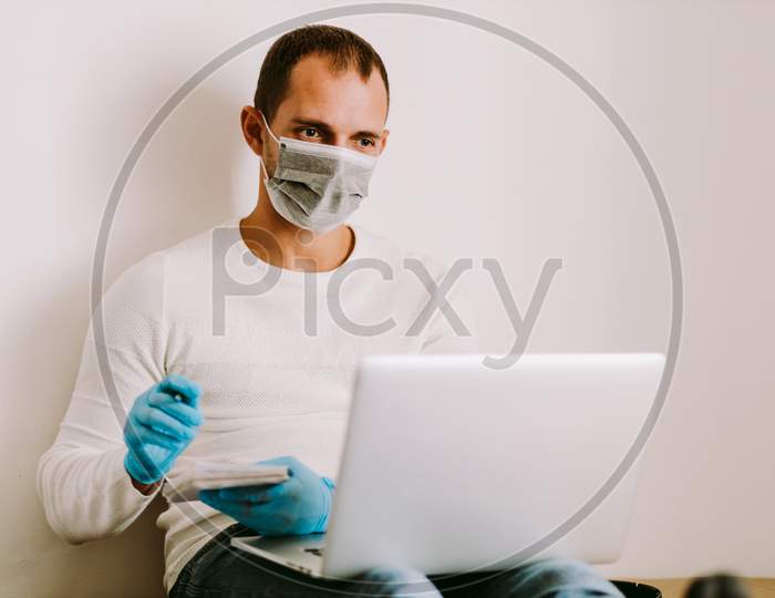Man Wearing Face Mask And Medical Gloves Work Remote At Home