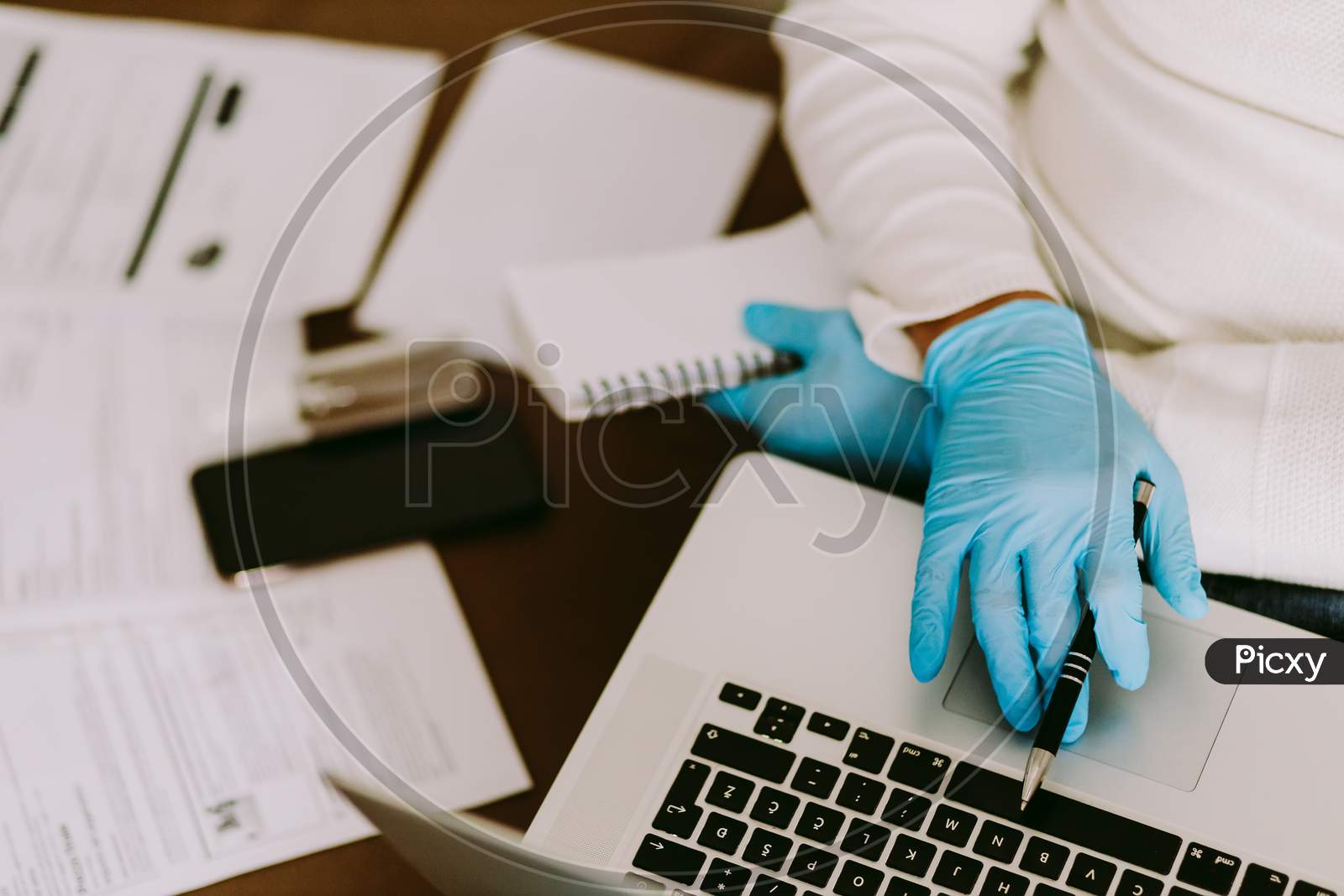 Man Working On Laptop And Wearing Latex Gloves For Virus Prevention