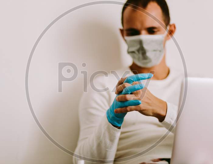 Man Wearing Latex Gloves And Face Mask
