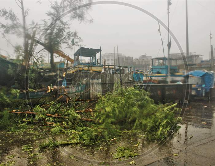 A tree falls on the road and a boat as cyclone Nisarga makes its landfall on the outskirts of the city, in Mumbai, India, June 3, 2020.