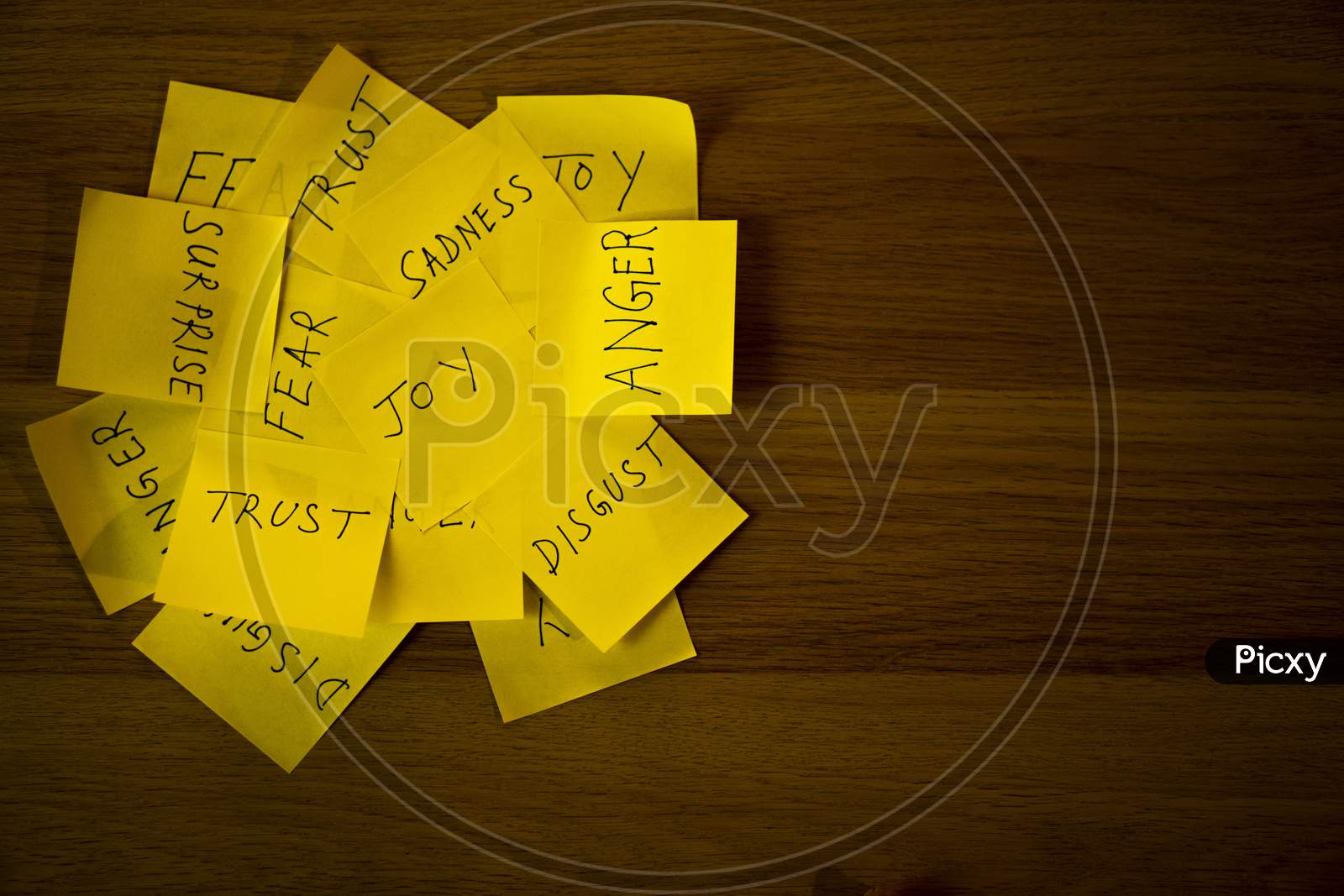 Types of human emotions written on a pile of sticky notes.