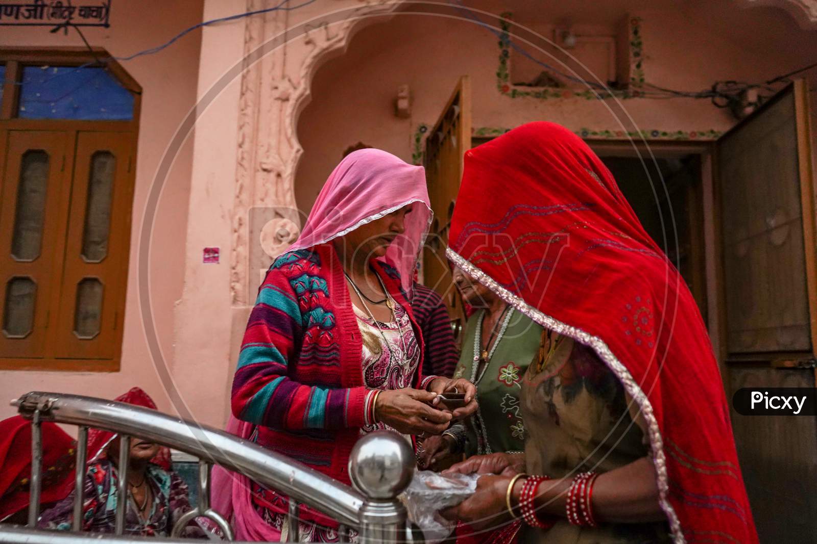 Pushkar, Rajasthan / India- June 5 2020 : Two Mid Aged Women In Veil Standing Near The Entrance Of Their Homes.
