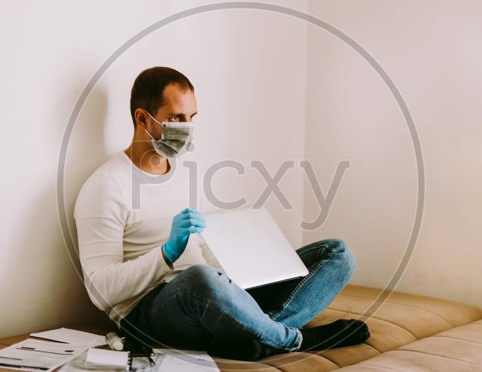 Man Working At Home Using Laptop And Smartphone During Quarantine