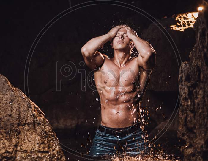Muscular Man Having Shower And Splashing Water