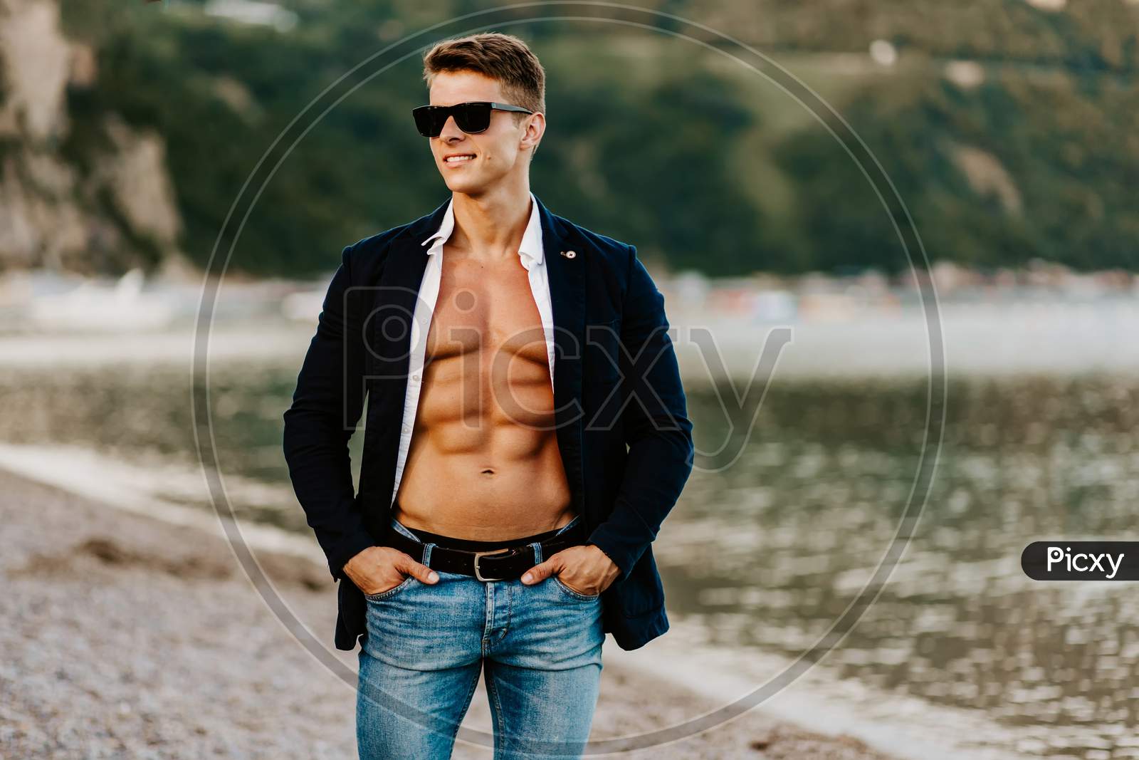 Stylish Muscular Handsome Man Wearing Jacket And Sunglasses Outdoors