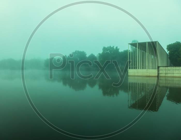 A Public Park With A Lake On A Foggy Morning
