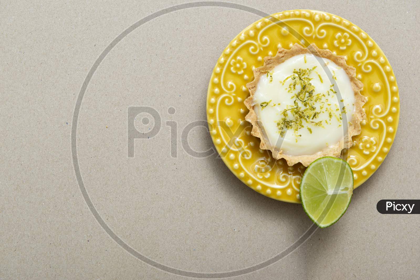Top View Of Lemon Tart On A Beautiful Yellow Vintage Plate.