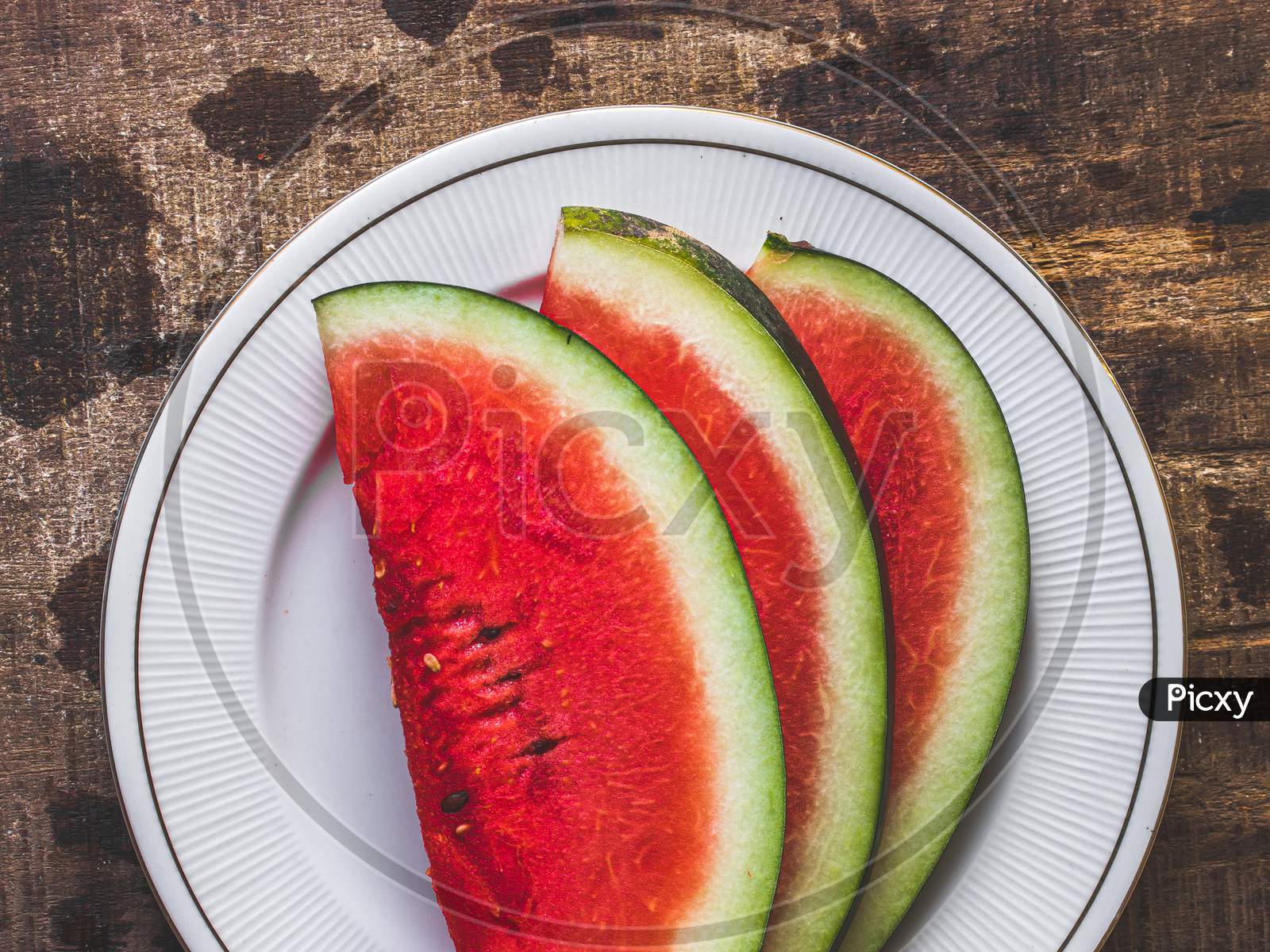 Sliced Watermelon on white plate with spoon and fork stock photo
