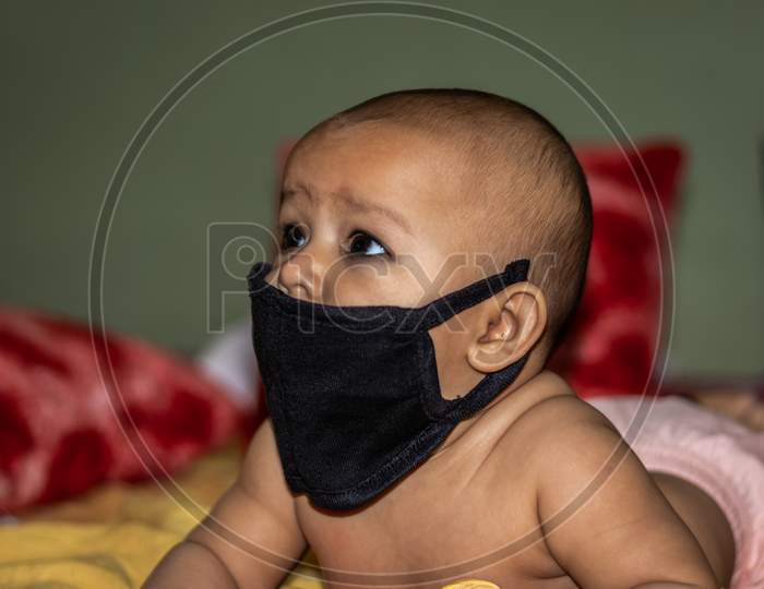 Child Wearing Black Mask For Protection Against Infections With Background Blur