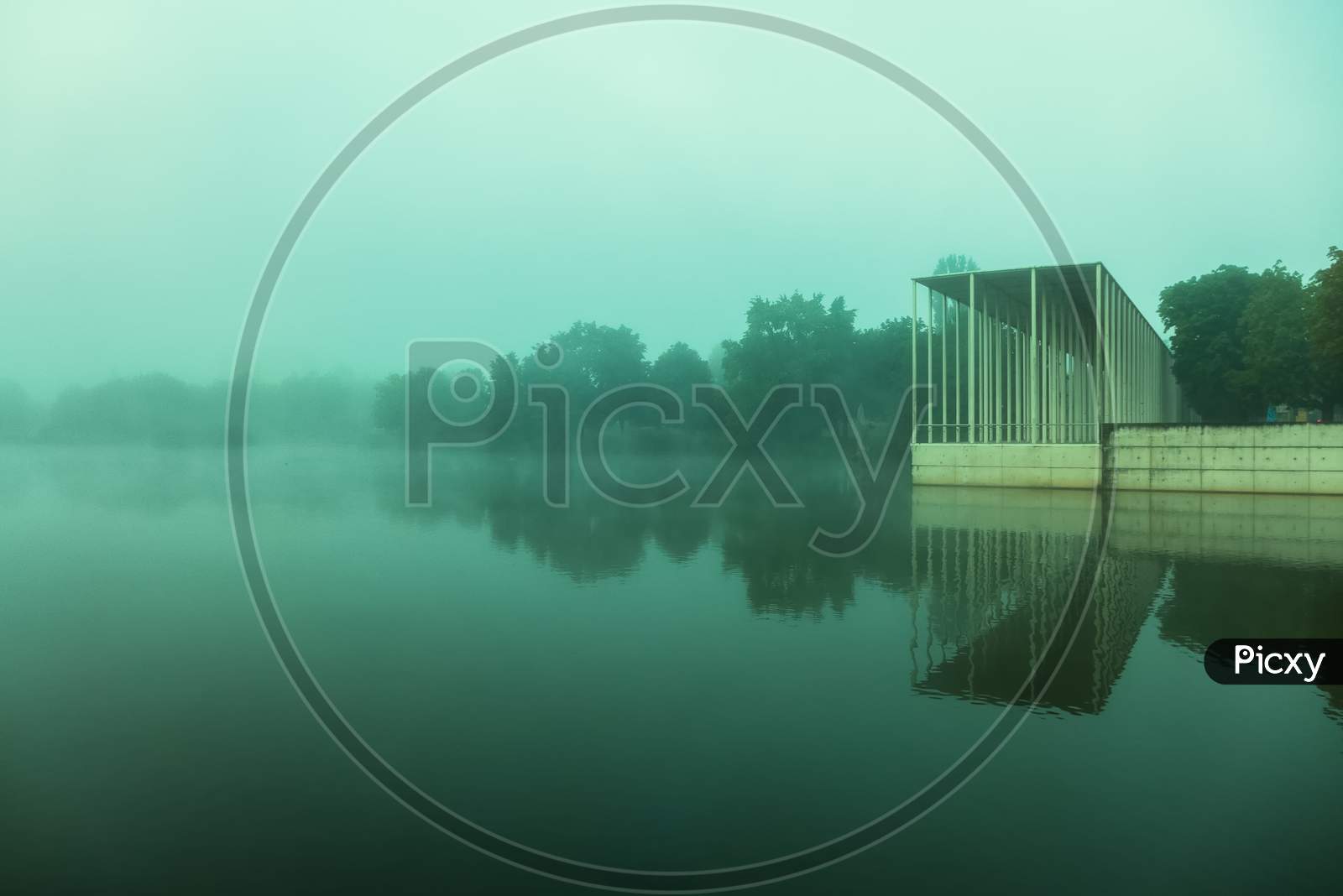 A Public Park With A Lake On A Foggy Morning