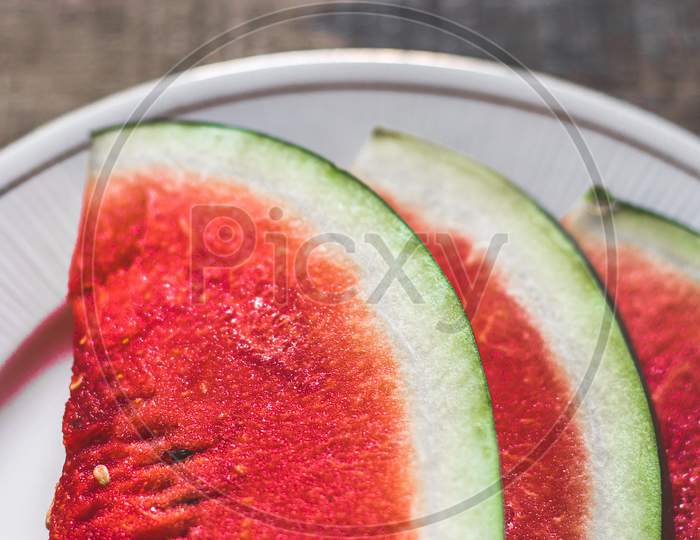 Sliced Watermelon on white plate with spoon and fork stock photo