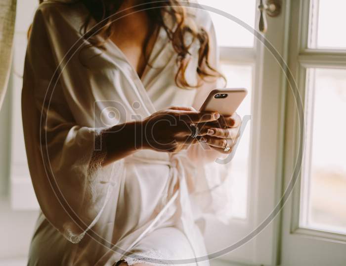 Woman In Bathrobe Using Smartphone At Home