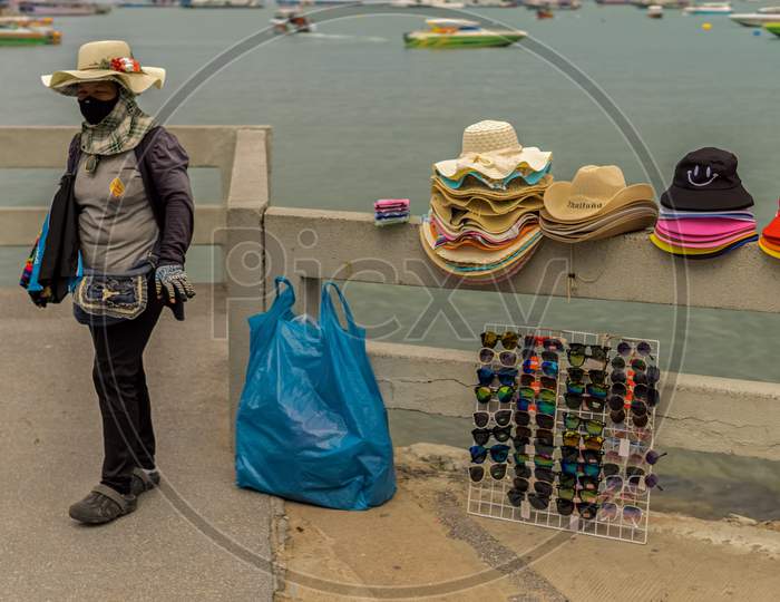 Pattaya,Thailand - October 25,2019:Bali Hai A Thai Woman Was Selling Colorful Hats A Sun Glasses To Tourists.
