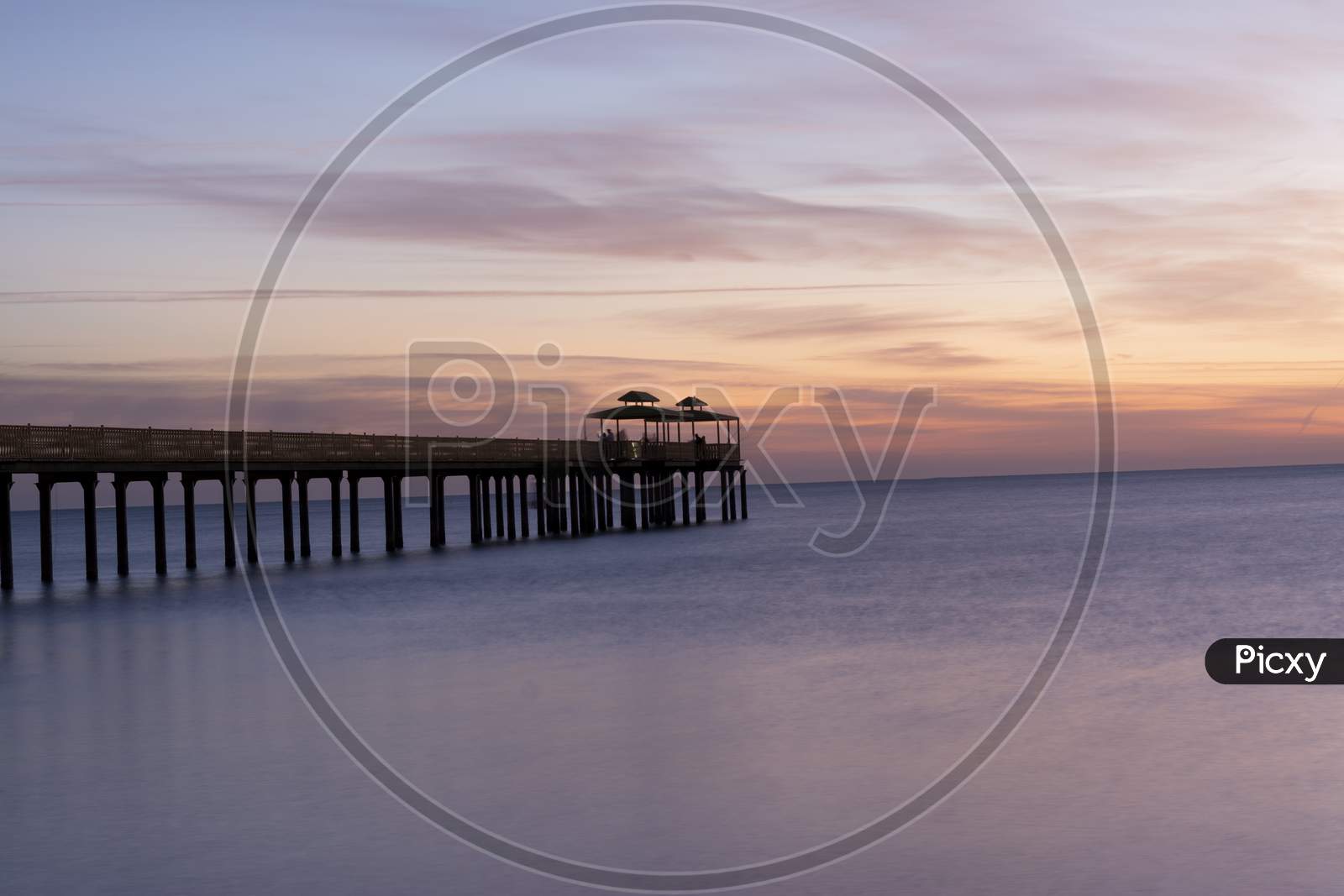 A Long exposure shot of early sunrise with fishing pier