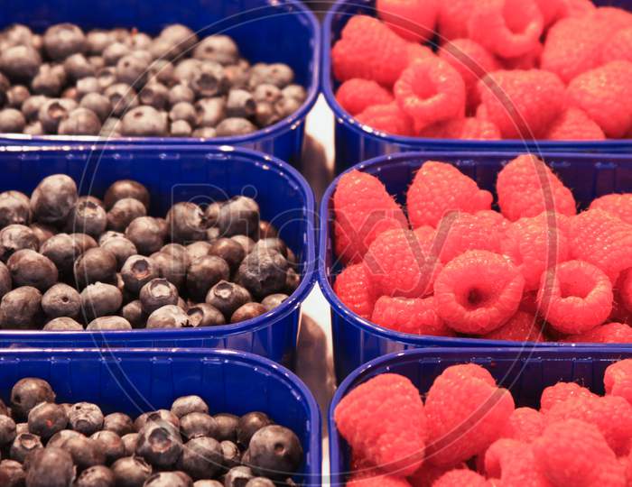 Blueberries And Raspberries In Boxes In Market